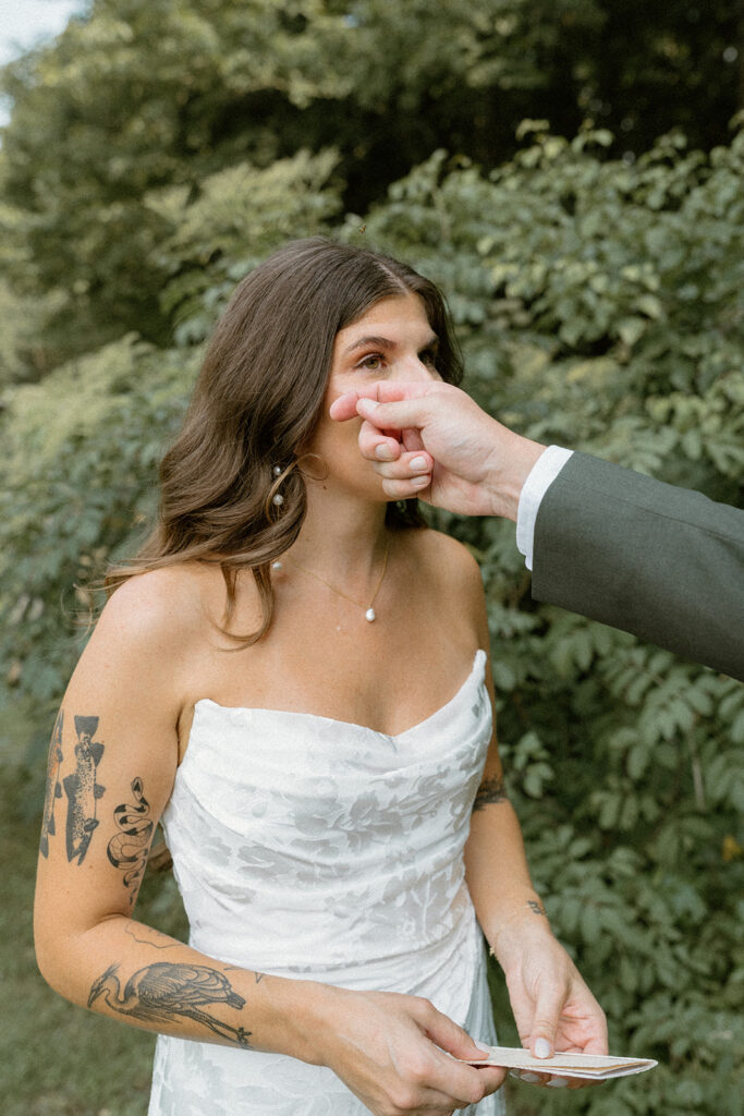 Groom wipes bride's tear during intimate wedding first look in Stowe, Vermont. 