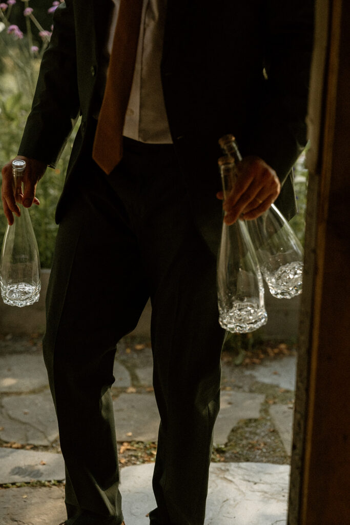 Wedding guest holding thrifted tableware at intimate wedding in Stowe, Vermont. 