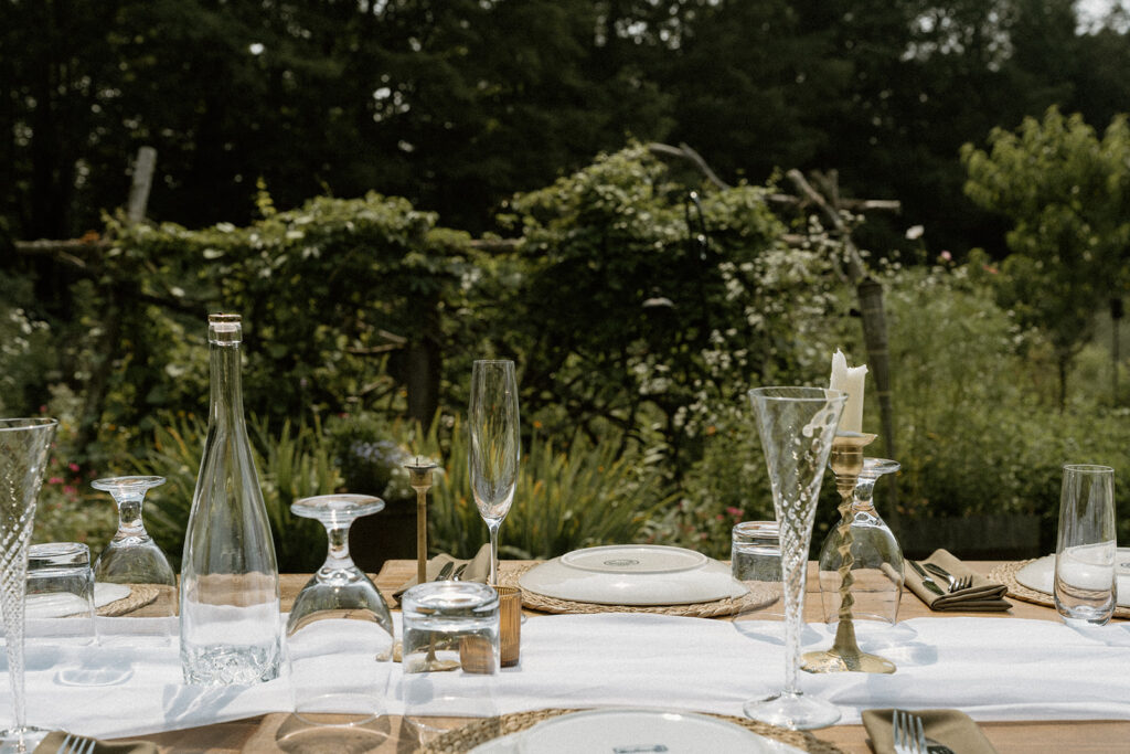Wide view of backyard garden reception table set for dinner at a cozy Vermont intimate wedding location.
