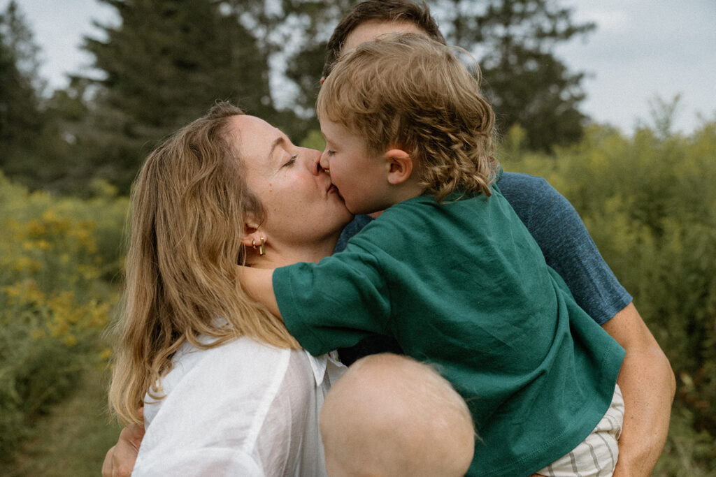 Mother kissing her young son while holding him