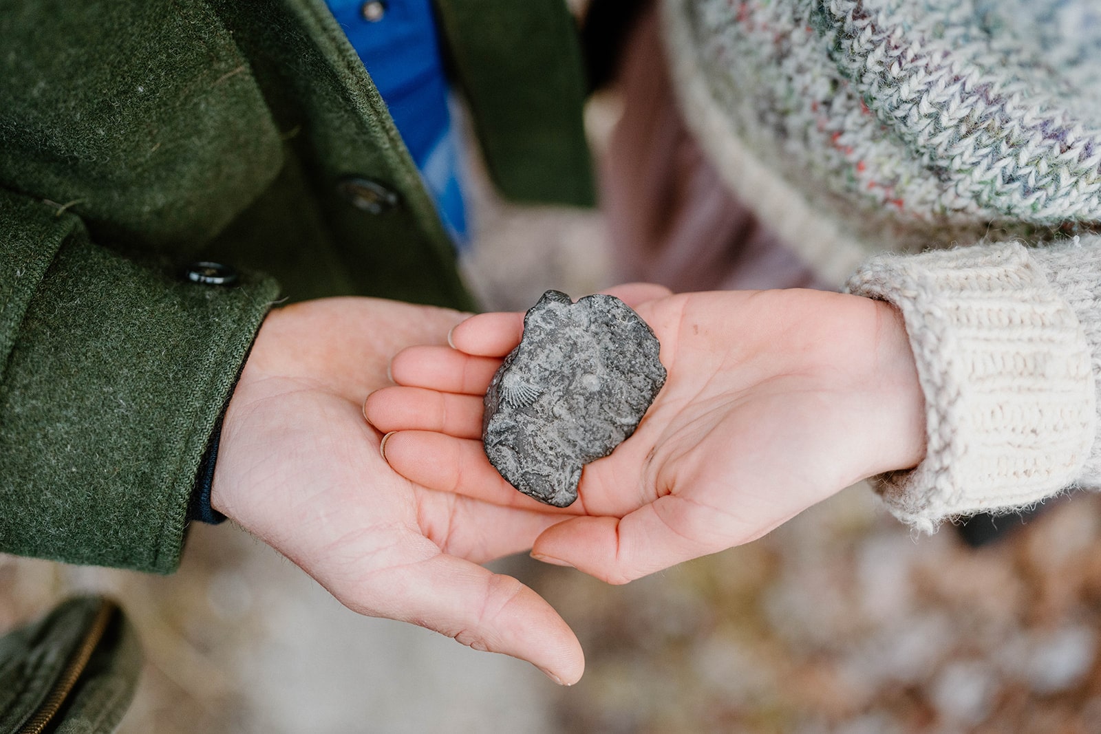 Two hands holding a rock during oathing ceremony at their intimate vermont elopement