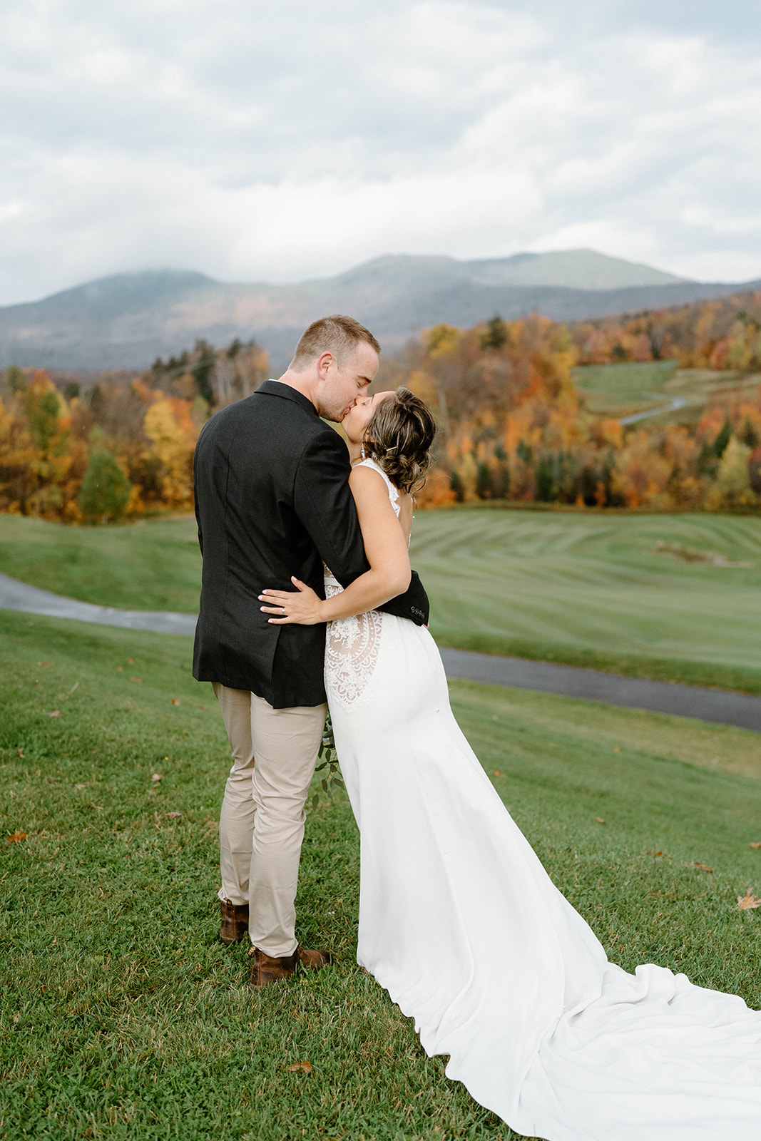 bride and groom kissing in front of autumn foliage at Jay Peak Resort in Jay, Vermont
