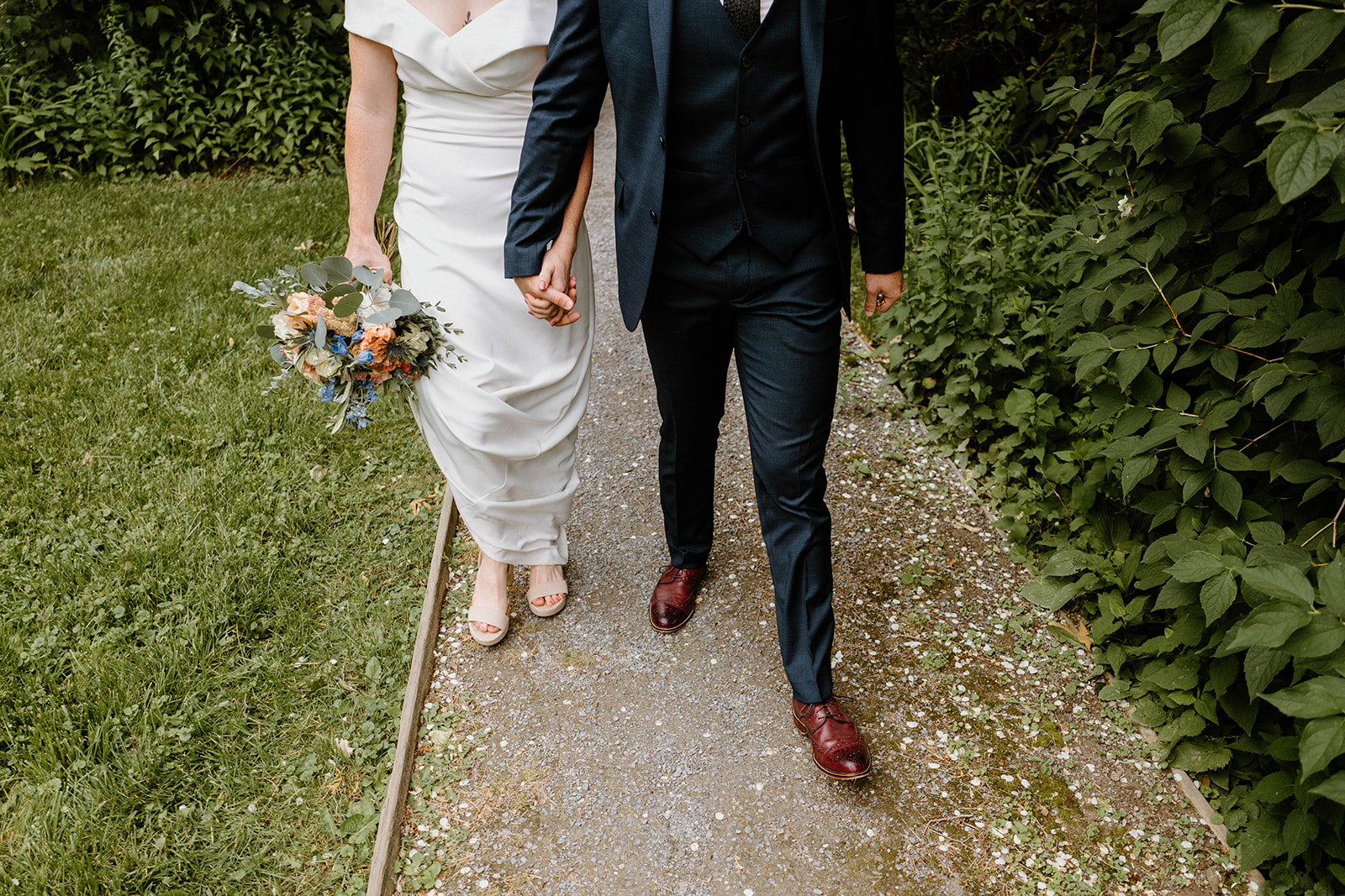 bride and groom walking along nature path at Mountain Top Resort in Chittenden, Vermont