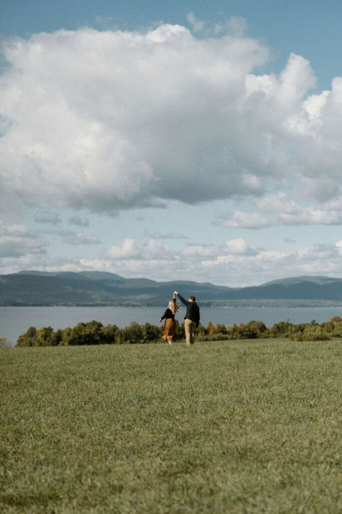 Shelburne Farms photography session — couple twirling in the rolling field