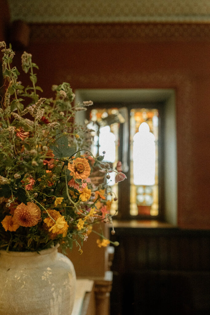 Seasonal wildflower arrangement displayed inside the historic Brick House during elegant Vermont museum wedding.